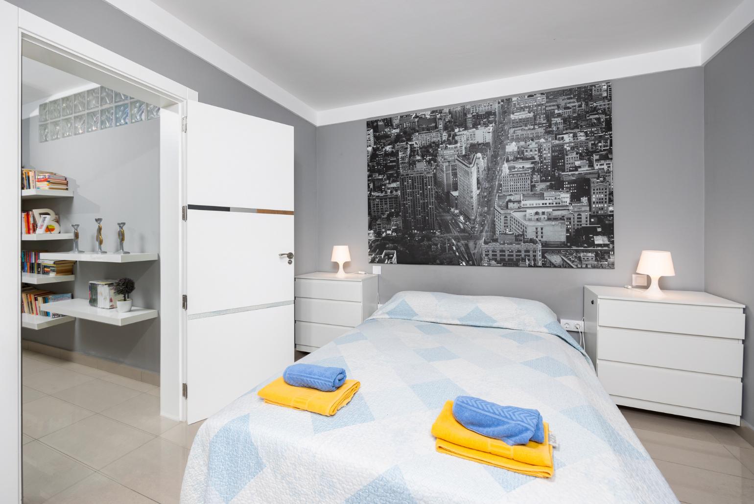 Double bedroom with A/C, sofa, and TV