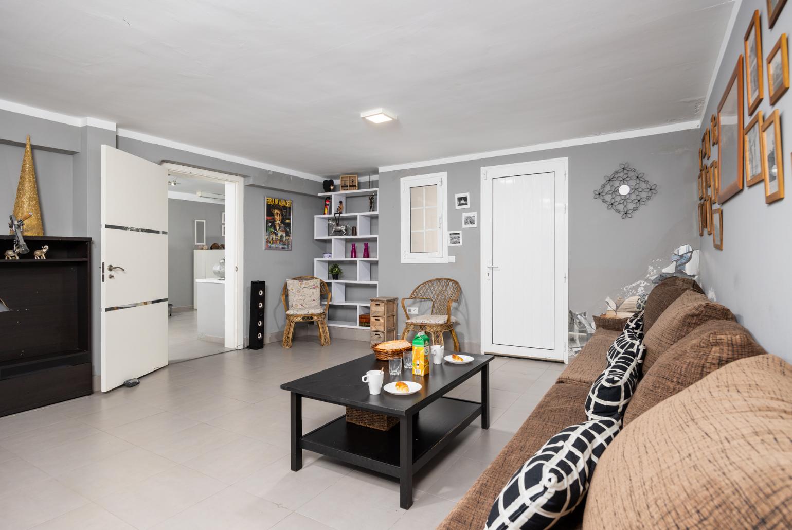 Living room with sofa, kitchen, and ornamental fireplace