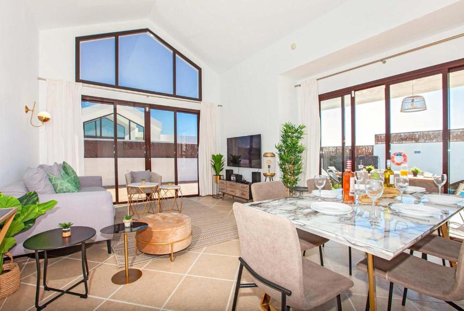 Open-plan living room with WiFi, A/C, comfortable sofas, TV, DVD, patio doors