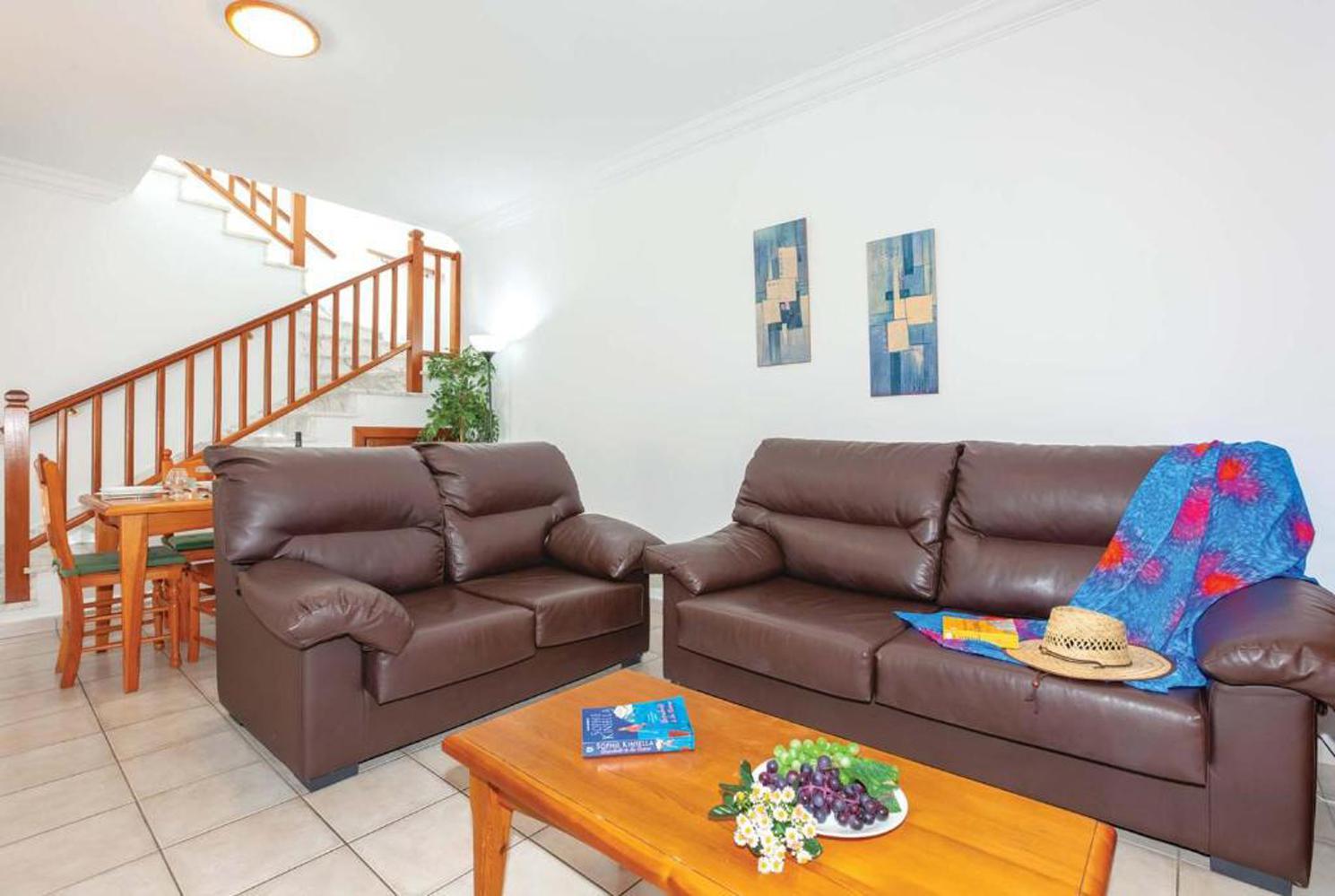 Open plan living room with comfortable sofas, WiFi, TV, dining area, A/C