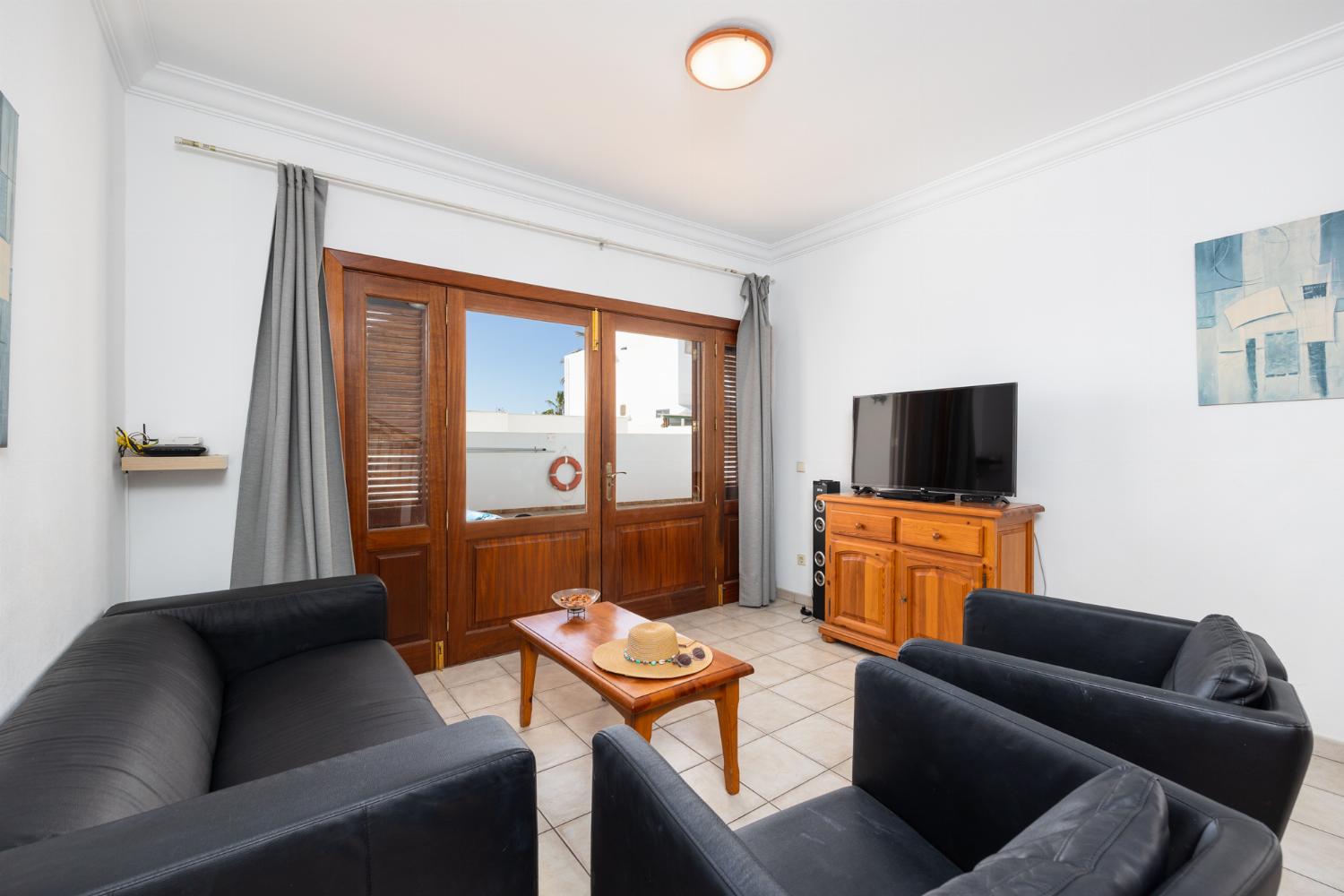 Living room with sofa, dining area, A/C, WiFi internet, and satellite TV