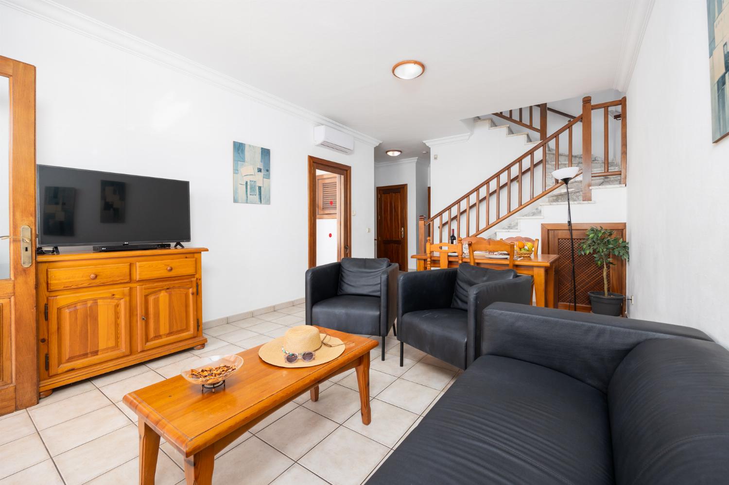 Living room with sofa, dining area, A/C, WiFi internet, and satellite TV