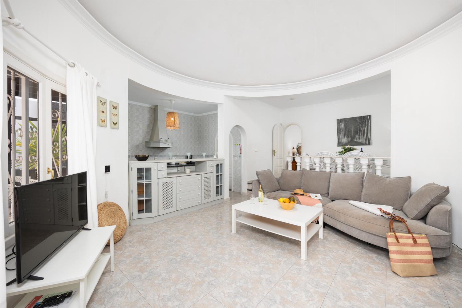 Open-plan living room with sofa, dining area, kitchen, WiFi internet, and satellite TV