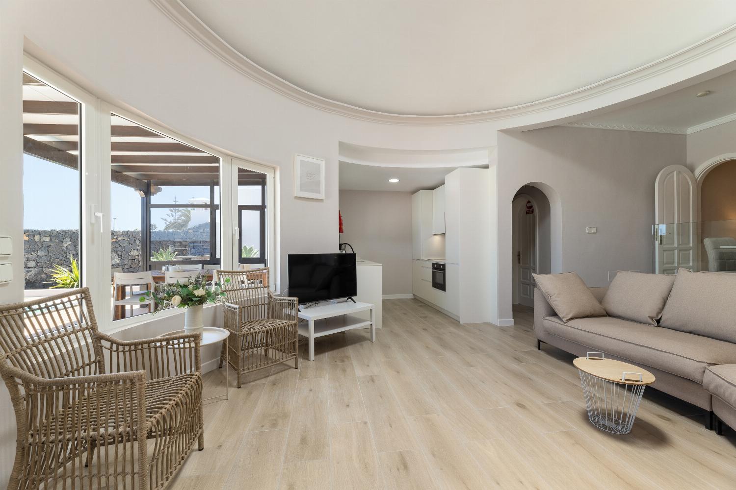 Open-plan living room with sofa, dining area, kitchen, WiFi internet, and satellite TV