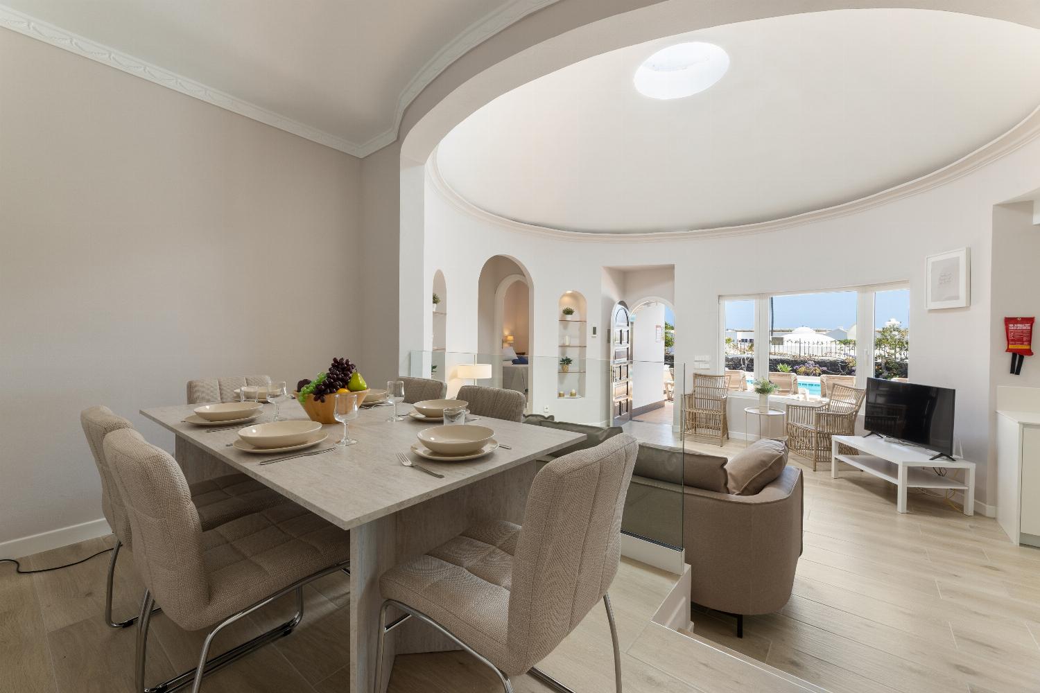 Open-plan living room with sofa, dining area, kitchen, WiFi internet, and satellite TV
