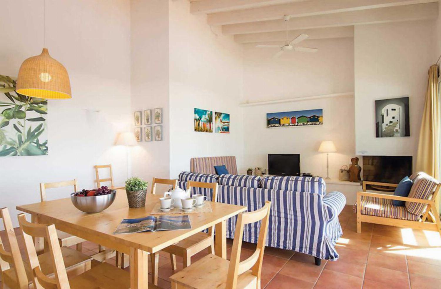 Open-plan living room with patio doors comfortable sofas TV, DVD, ornamental fireplace and dining area