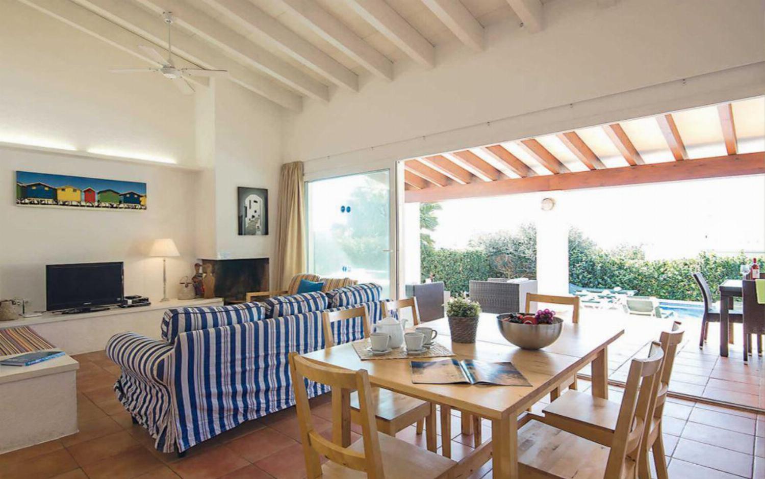 Open-plan living room with patio doors comfortable sofas TV, DVD, ornamental fireplace and dining area