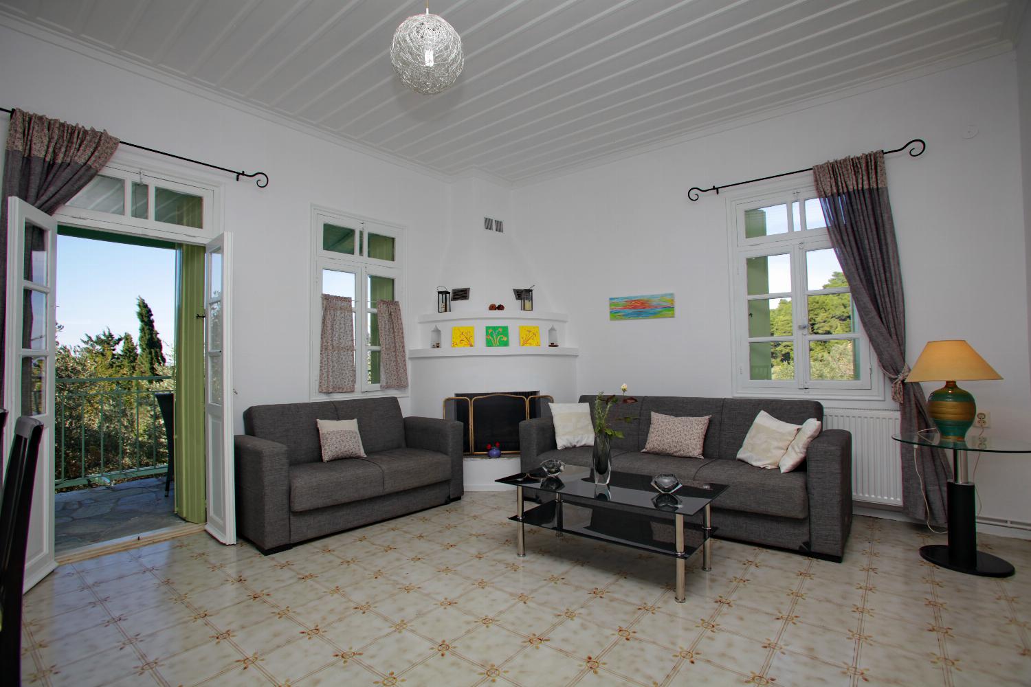Open-plan living room with sofa, ornamental fireplace, dining area, kitchen, WiFi internet, satellite TV