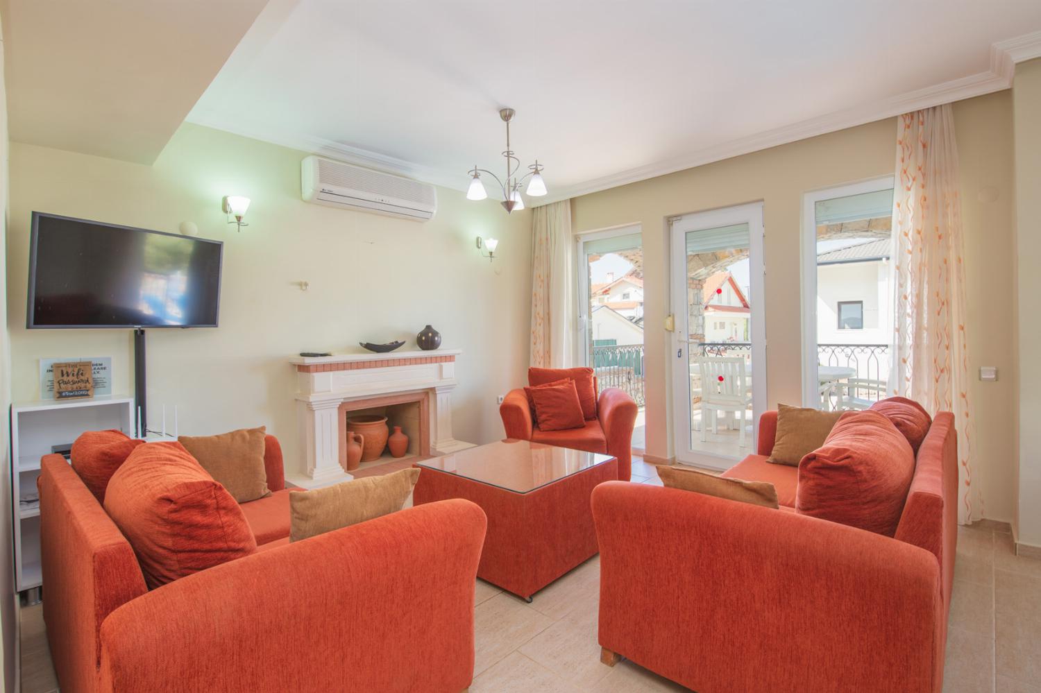 Open-plan living room with A/C, WiFi, TV, DVD, comfortable sofas, ornamental fireplace, dining area