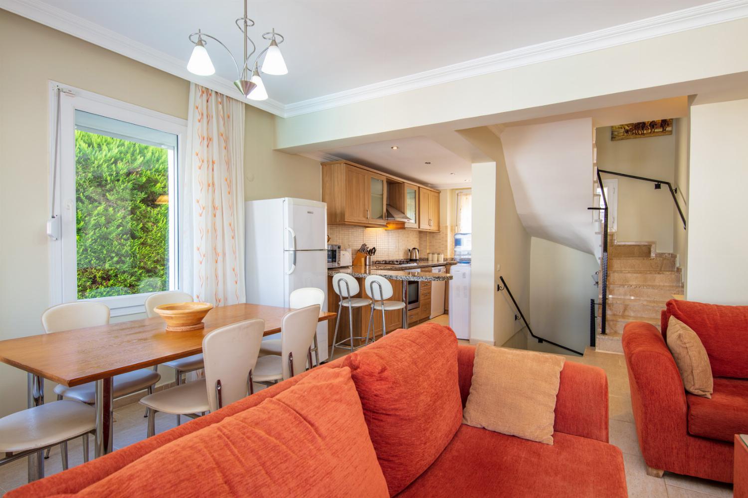 Open-plan living room with A/C, WiFi, TV, DVD, comfortable sofas, ornamental fireplace, dining area