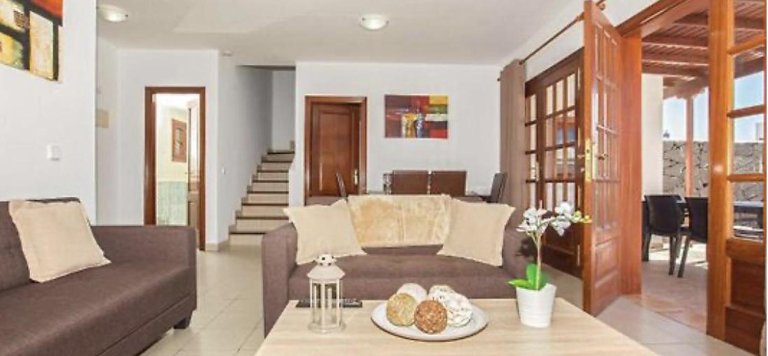 Open plan living room with comfortable sofas, TV, AC, WiFi, patio doors and dining area