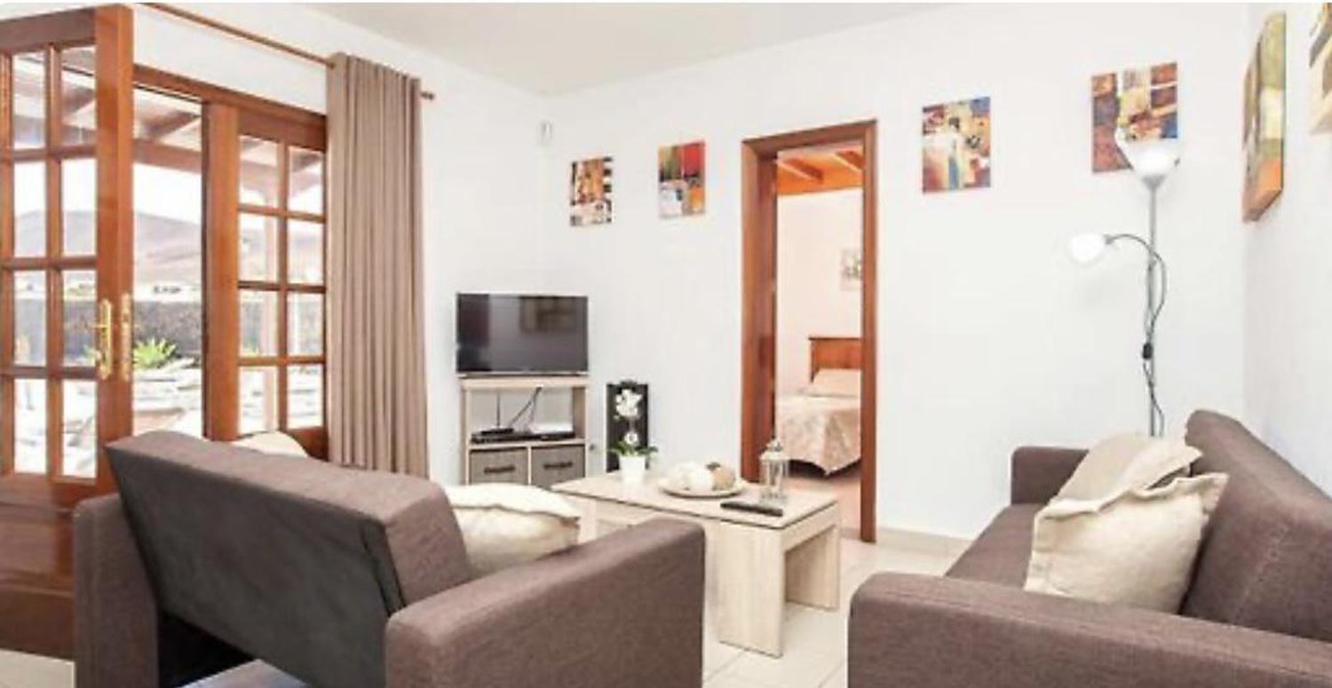 Open plan living room with comfortable sofas, TV, AC, WiFi, patio doors and dining area