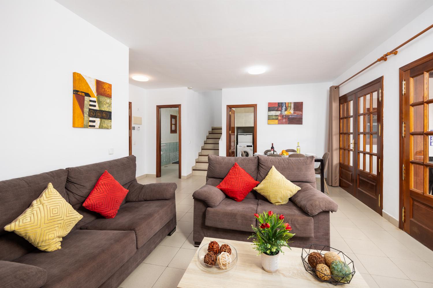 Living room with sofas, dining area, WiFi internet, and TV