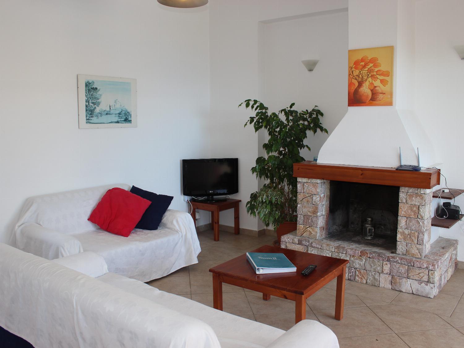 Open-plan living room with sofas, dining areas and kitchen