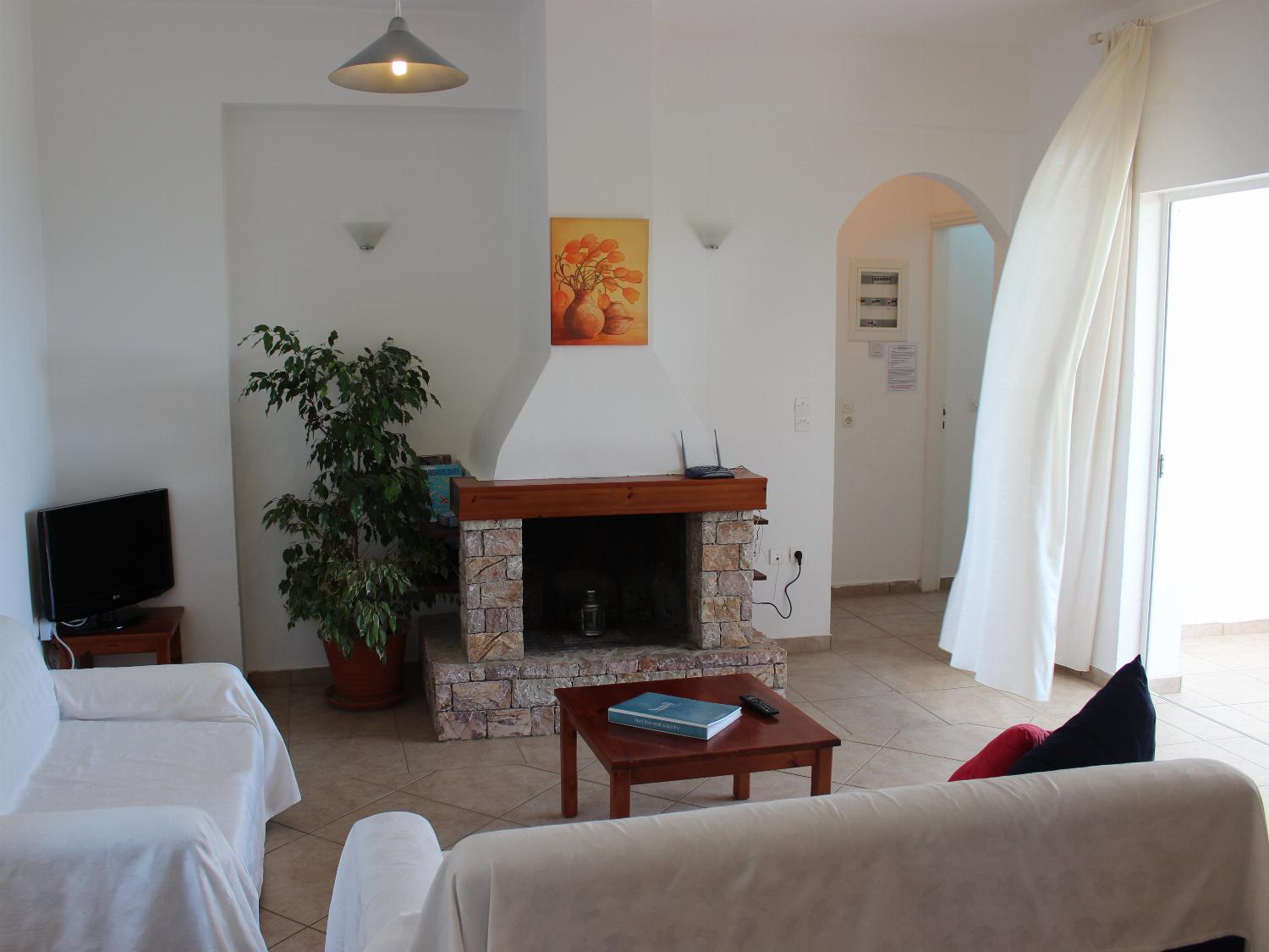 Open-plan living room with sofas, dining areas and kitchen