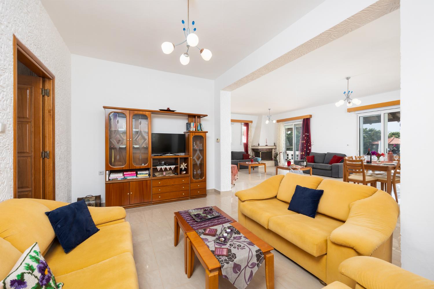 Living room with sofas, dining area, ornamental fireplace, A/C, WiFi internet, and satellite TV
