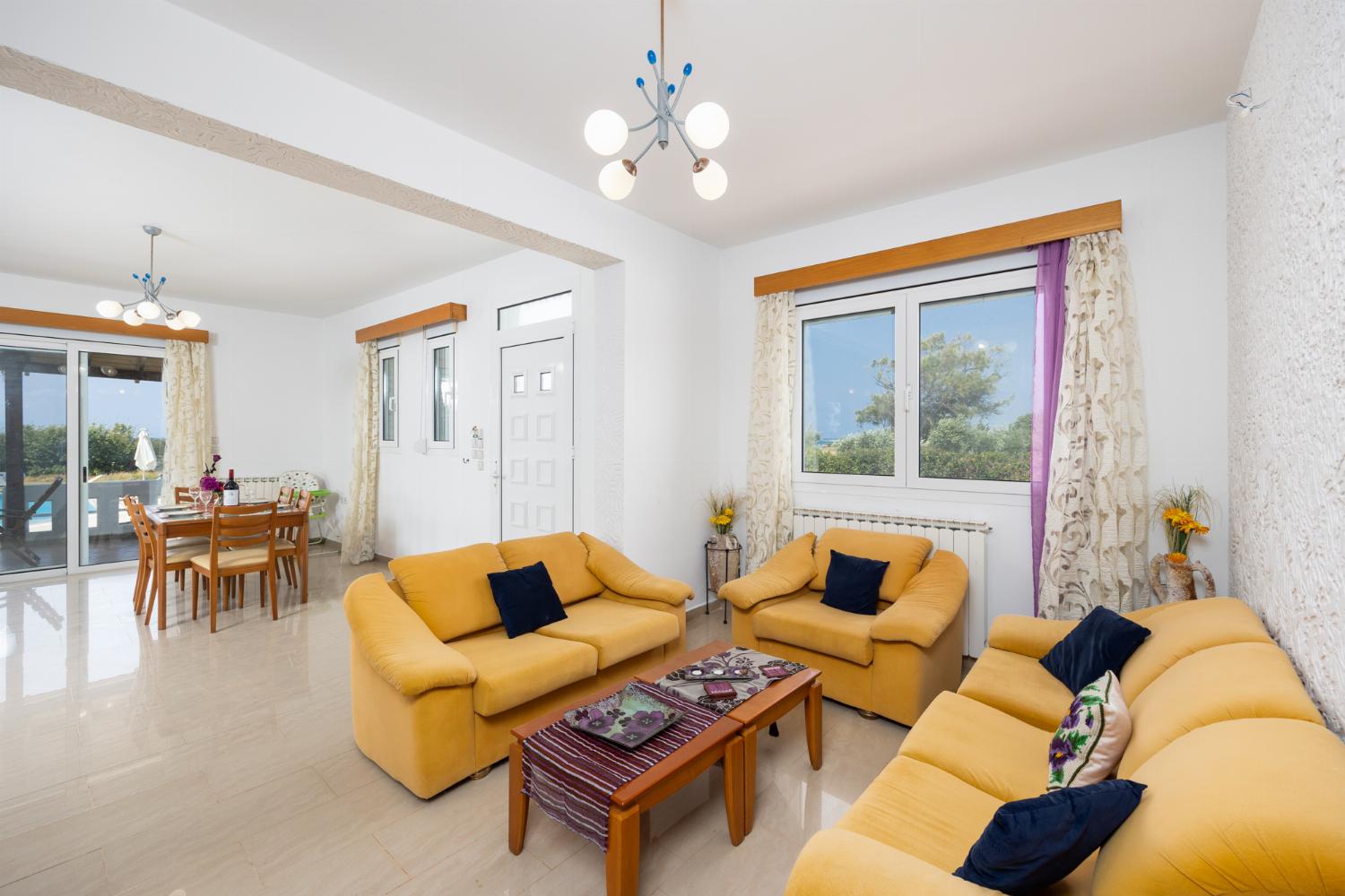 Living room with sofas, dining area, ornamental fireplace, A/C, WiFi internet, and satellite TV