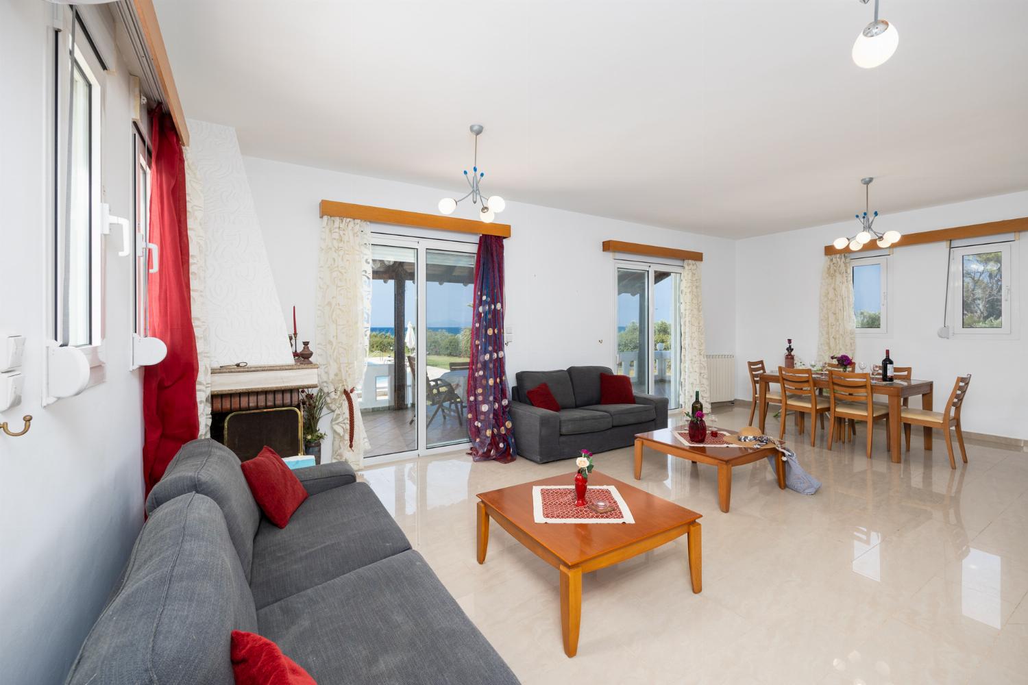 Living room with sofas, dining area, ornamental fireplace, A/C, WiFi internet, and satellite TV