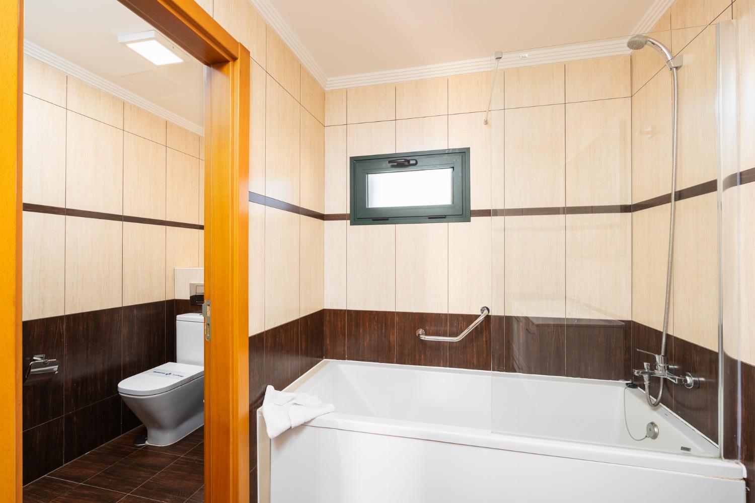 En suite bathroom with bath and shower