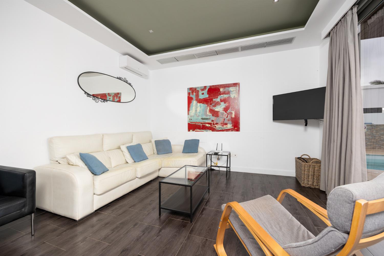 Living room with sofa, dining area, A/C, WiFi internet, and satellite TV