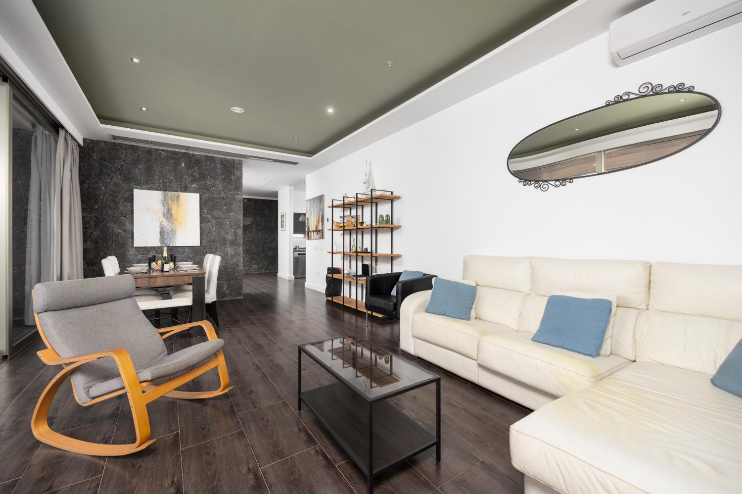 Living room with sofa, dining area, A/C, WiFi internet, and satellite TV