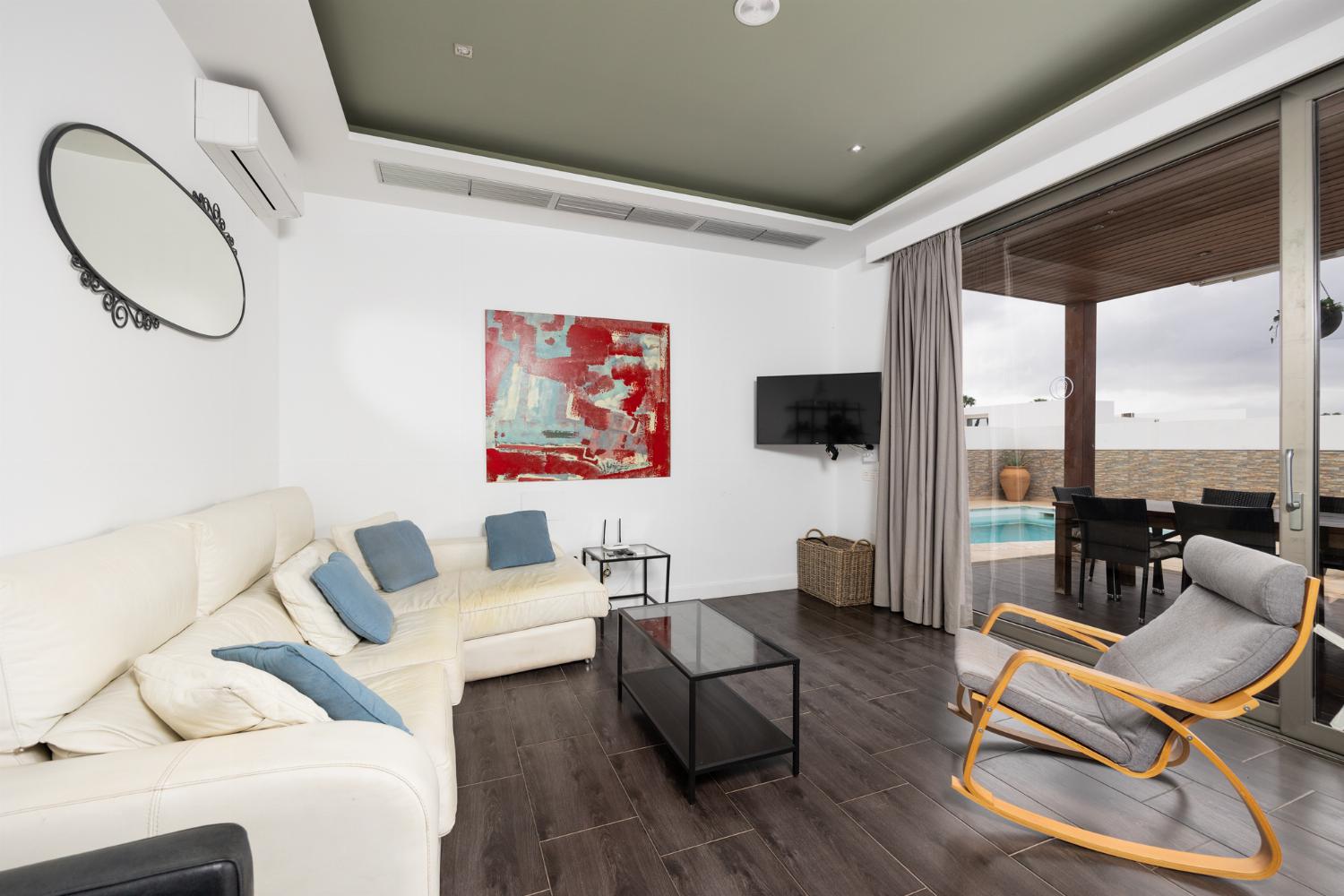 Living room with sofa, dining area, A/C, WiFi internet, and satellite TV