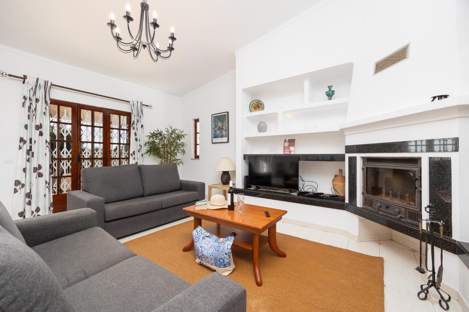 Living room with sofas, dining area, ornamental fireplace, A/C, WiFi internet, and satellite TV