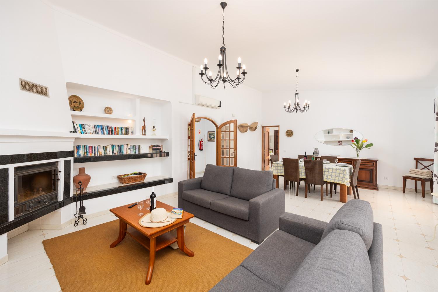 Living room with sofas, dining area, ornamental fireplace, A/C, WiFi internet, and satellite TV