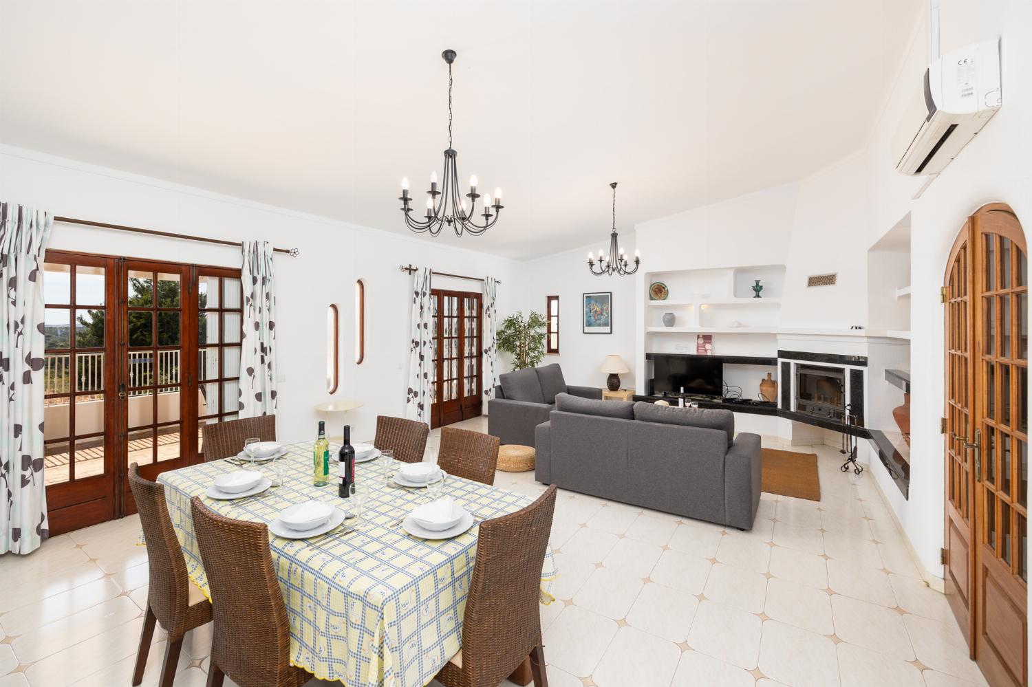 Living room with sofas, dining area, ornamental fireplace, A/C, WiFi internet, and satellite TV