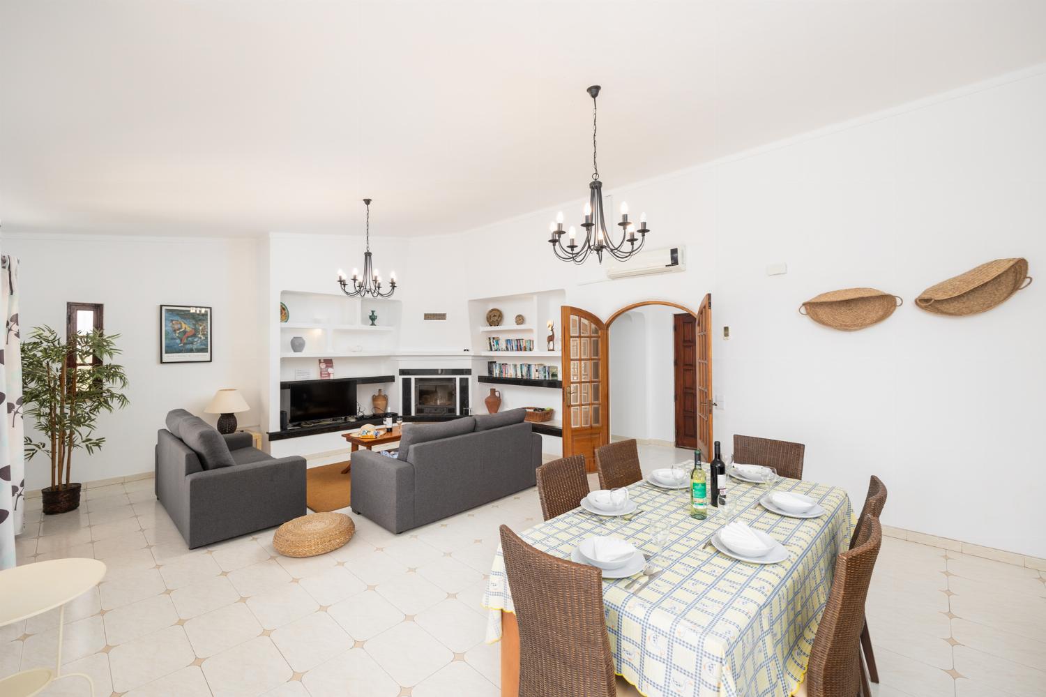 Living room with sofas, dining area, ornamental fireplace, A/C, WiFi internet, and satellite TV