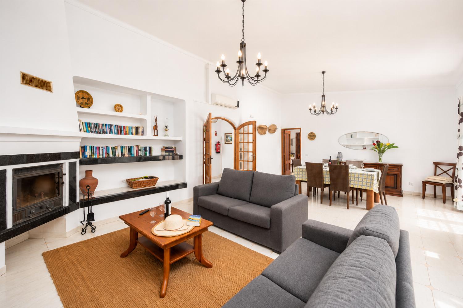 Living room with sofas, dining area, ornamental fireplace, A/C, WiFi internet, and satellite TV