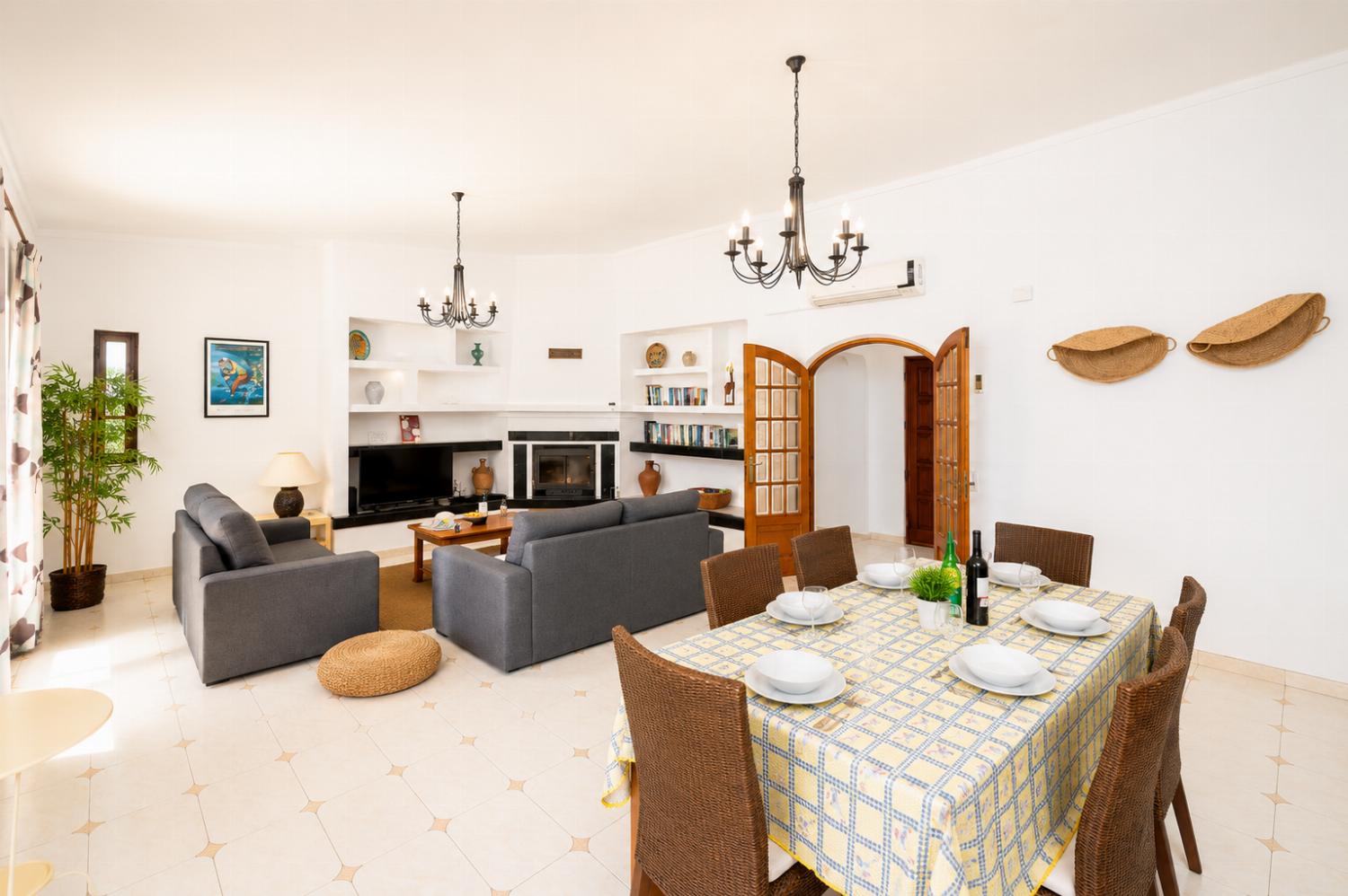 Living room with sofas, dining area, ornamental fireplace, A/C, WiFi internet, and satellite TV