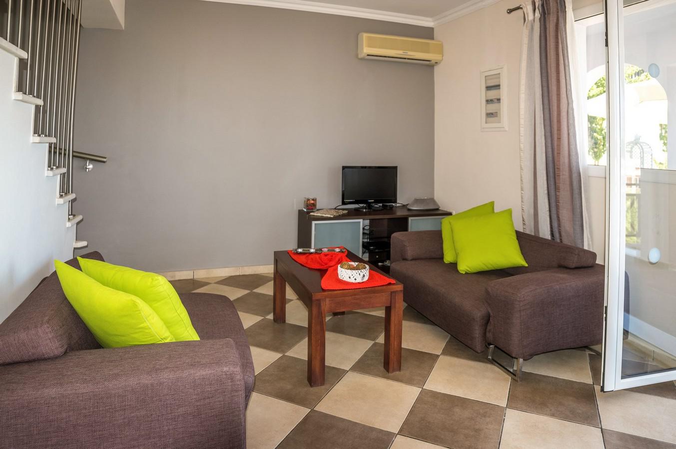 Open plan living room with TV, A/C, WiFi, patio doors