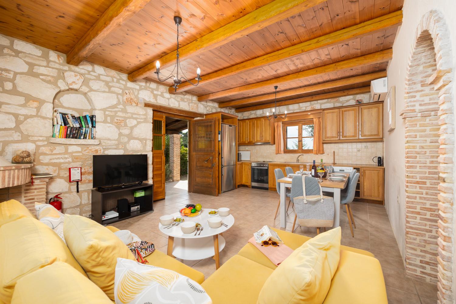 Open-plan living room with sofa, dining area, kitchen, ornamental fireplace, A/C, WiFi internet, and satellite TV