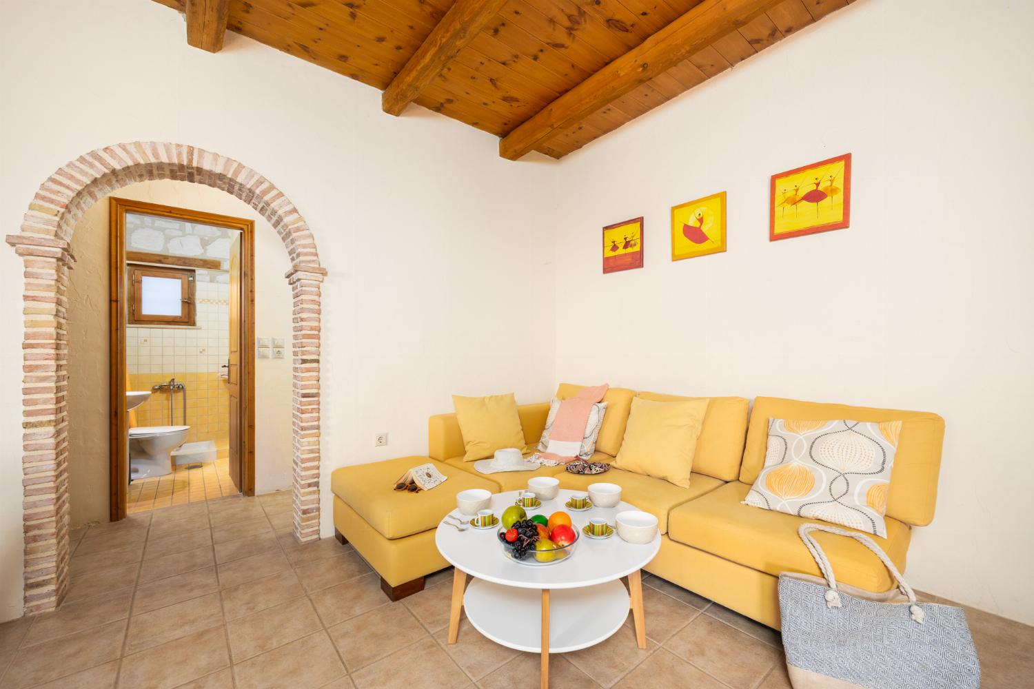 Open-plan living room with sofa, dining area, kitchen, ornamental fireplace, A/C, WiFi internet, and satellite TV