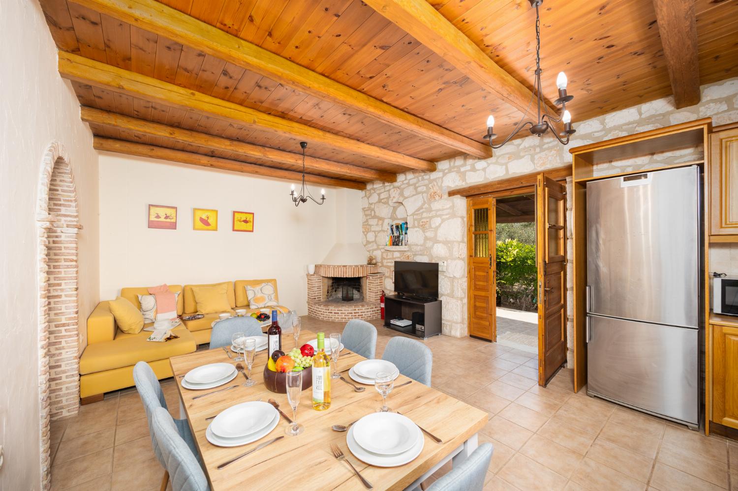 Open-plan living room with sofa, dining area, kitchen, ornamental fireplace, A/C, WiFi internet, and satellite TV