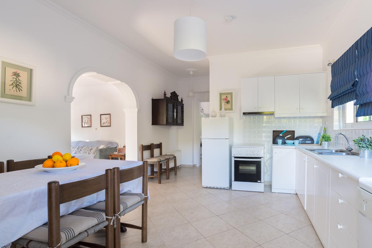 Open-plan living room with sofas, dining areas and kitchen
