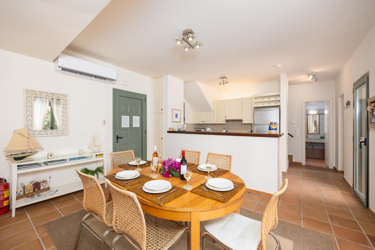 Open-plan living room with sofas, dining area, kitchen, A/C, WiFi internet, and satellite TV