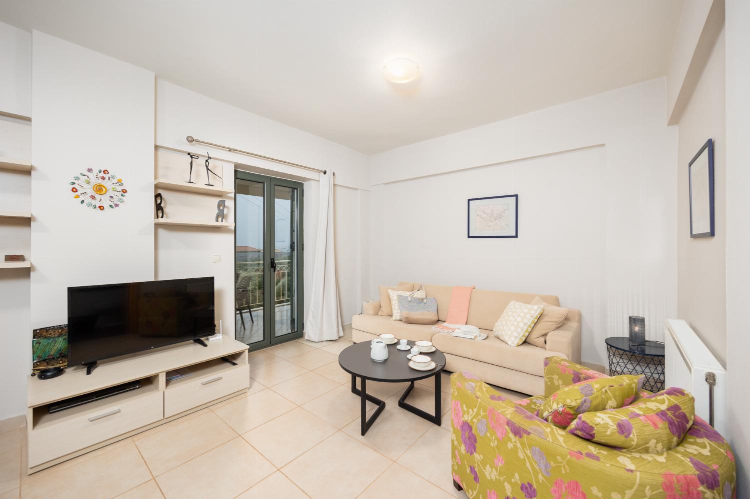 Open-plan living room with sofa, dining area, kitchen, A/C, WiFi internet, and satellite TV