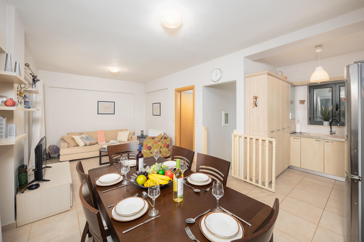 Open-plan living room with sofa, dining area, kitchen, A/C, WiFi internet, and satellite TV