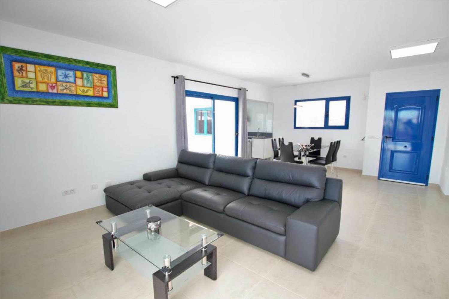 Open plan living room with comfortable sofas, WiFi, TV, dining area, A/C