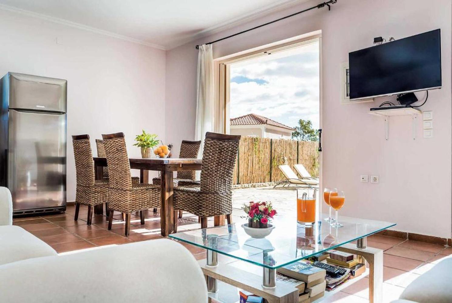 Open plan living room with TV, WiFi, comfortable sofas, dining area, patio doors