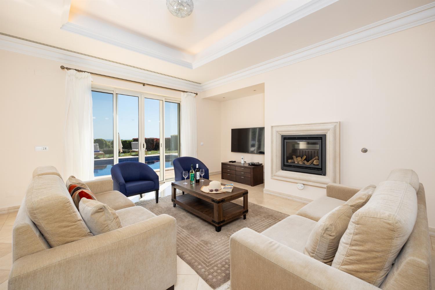 Living room with sofas, dining area, ornamental fireplace, A/C, WiFi internet, and satellite TV