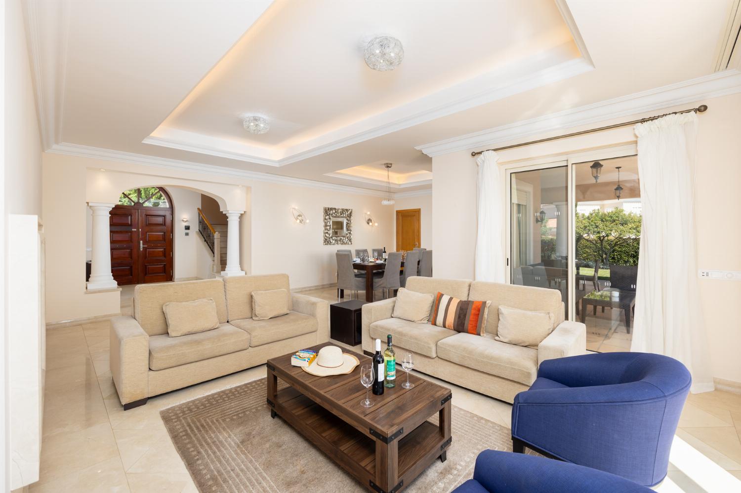 Living room with sofas, dining area, ornamental fireplace, A/C, WiFi internet, and satellite TV