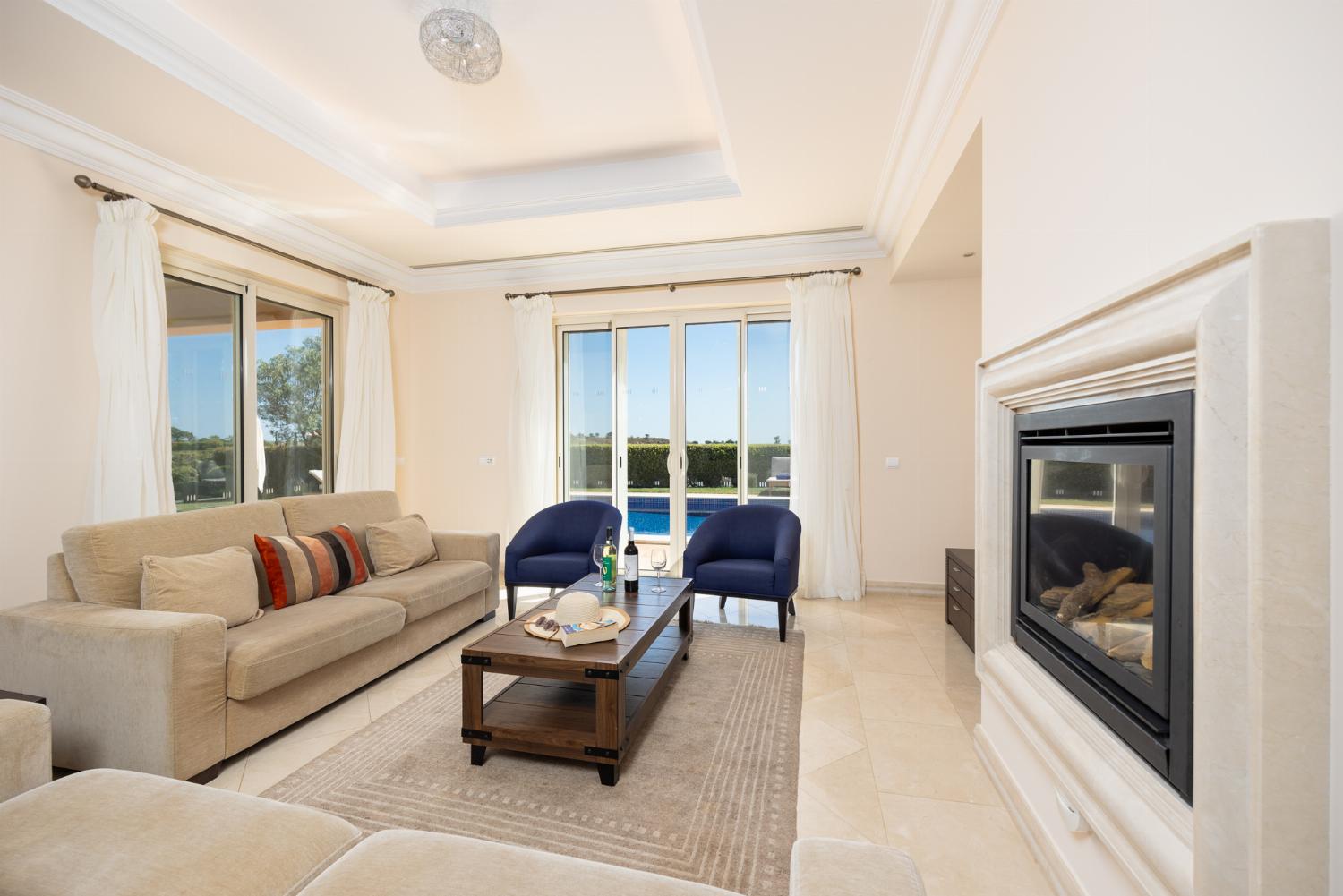 Living room with sofas, dining area, ornamental fireplace, A/C, WiFi internet, and satellite TV