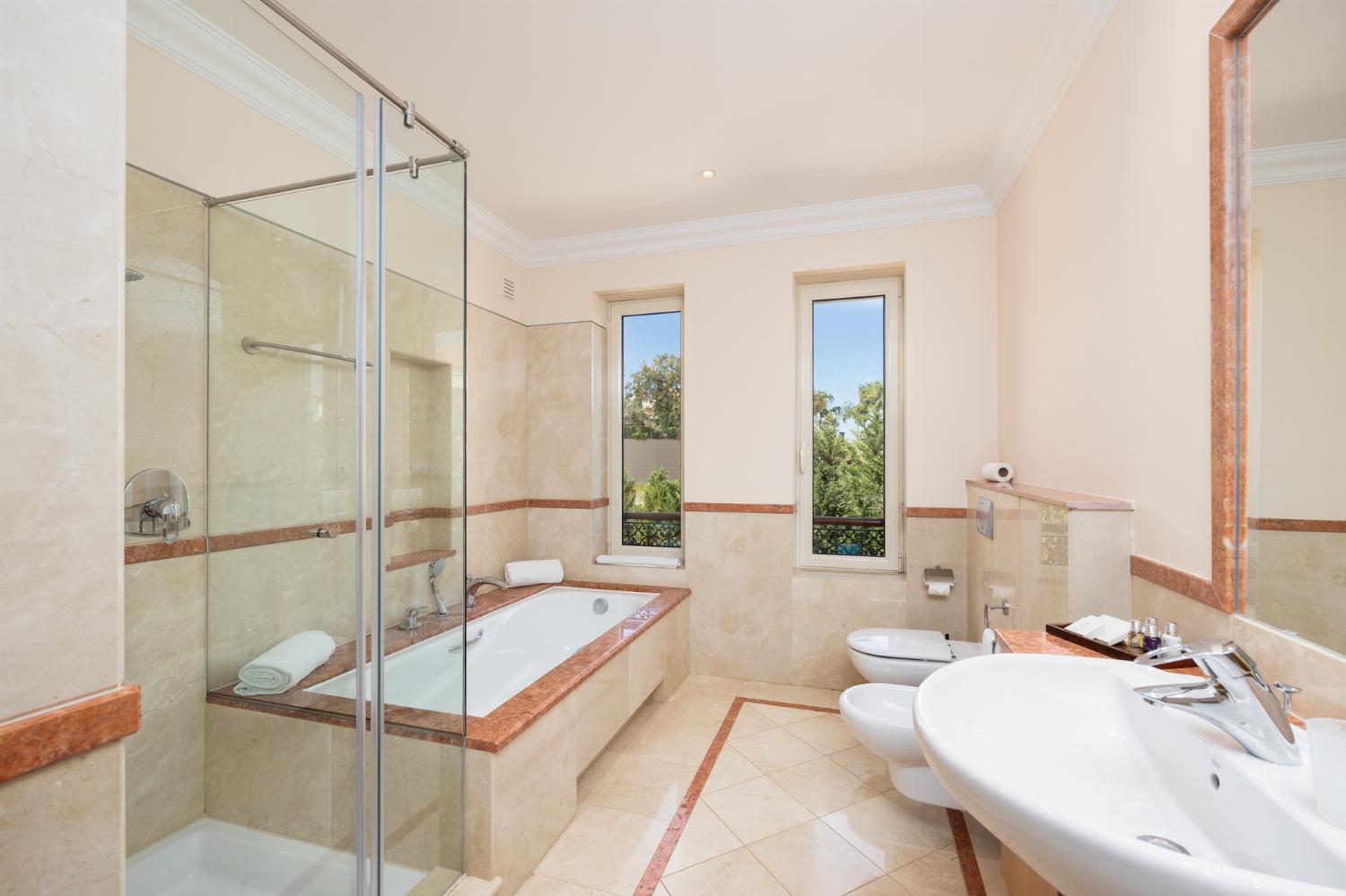En suite bathroom with bath and shower