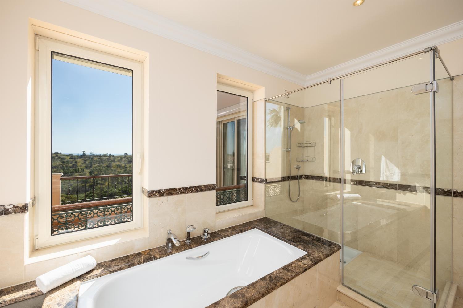 En suite bathroom with bath and shower