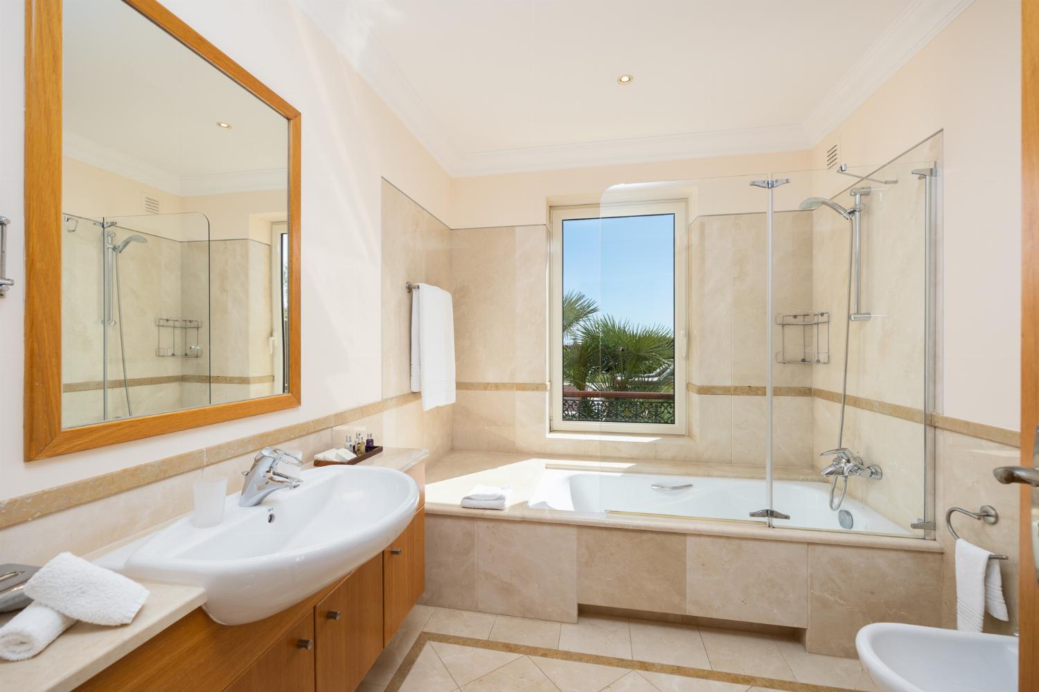 En suite bathroom with bath and shower