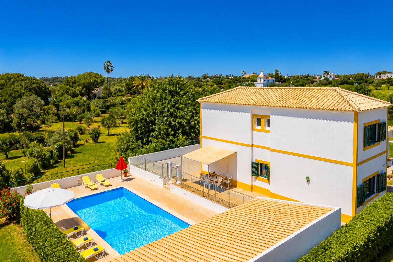 Beautiful villa with a private pool, sunny terrace, and lush green surroundings.