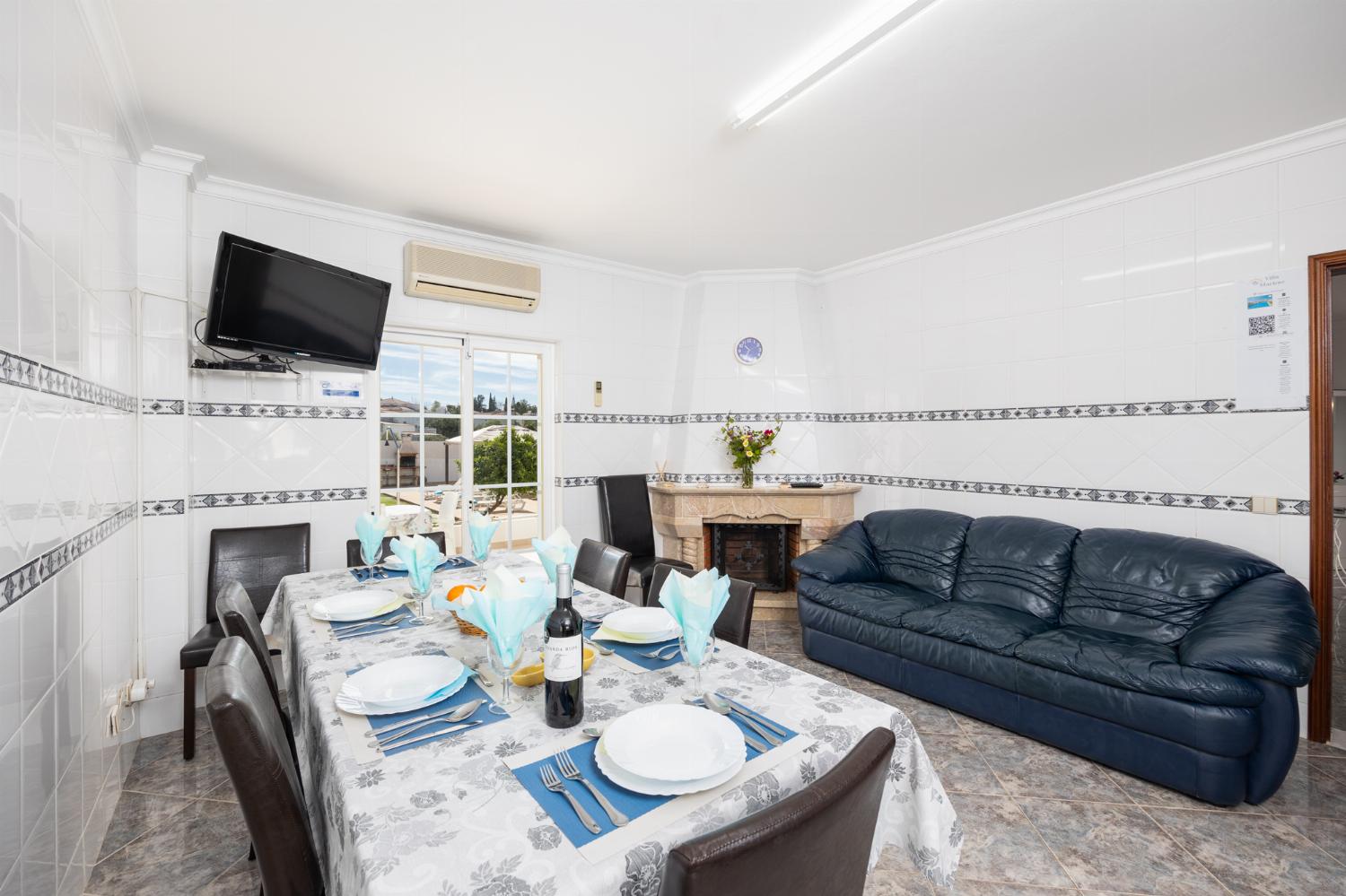 Dining area with sofa, ornamental fireplace, A/C, and TV